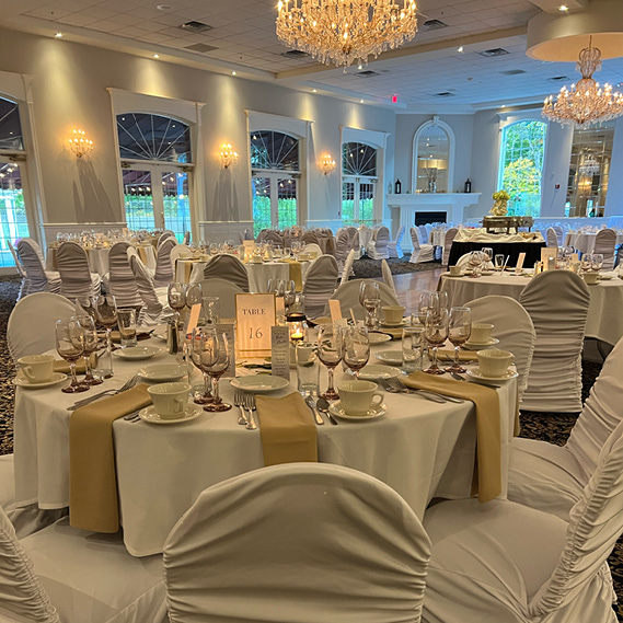 Large room decorated for a wedding with french doors, chandeliers and a fireplace