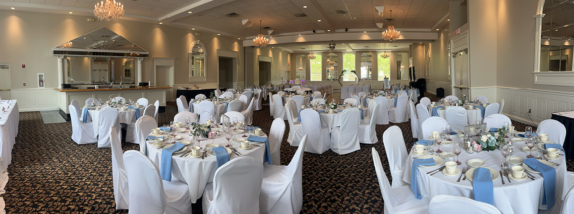 Banquet hall with white and blue table settings.