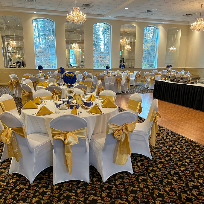 Banquet hall decorated for a prom with blue and gold linens