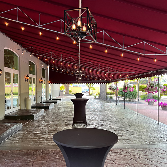 Patio with red awning and high top tables